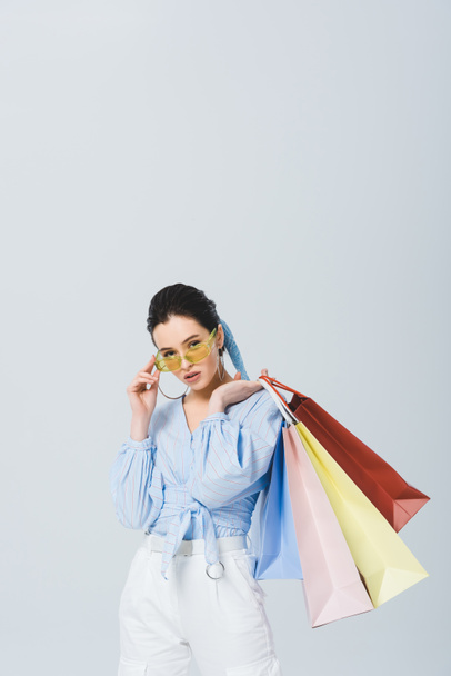 beautiful stylish girl with shopping bags isolated on grey - Фото, изображение