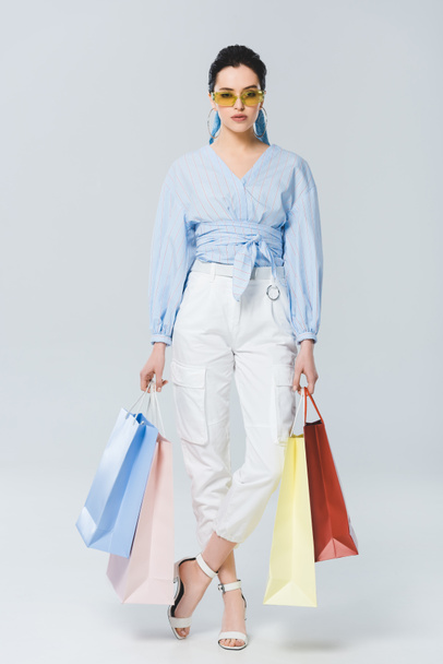 beautiful fashionable girl with shopping bags on grey - Valokuva, kuva