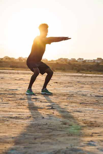 Young sports man make fitness exercises outdoors. - Foto, imagen