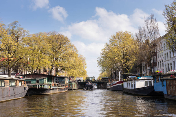 AMSTERDAM, NETHERLANDS - APRIL 14, 2019: Houses and Boats on Ams - Photo, Image