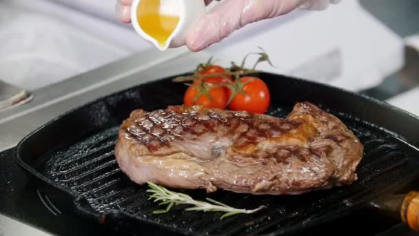 Restaurant keuken. Chef Frituur stuk steak in de pan. Een SAP bovenop toevoegen - Video