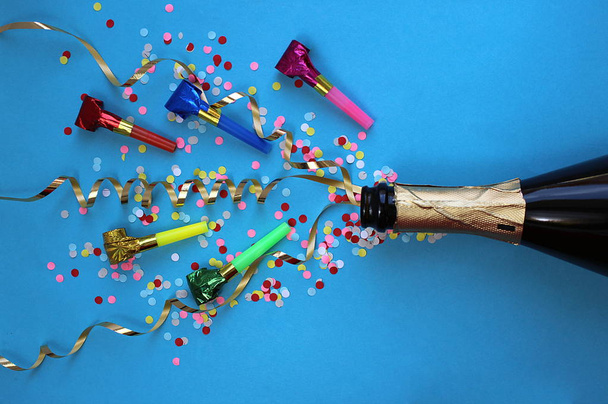 Festive ribbons, confetti and pipes flew out of the champagne bottle - Fotoğraf, Görsel