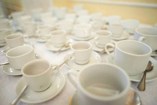 Много белых чистых чашек кофе на столе  - Фото, изображение