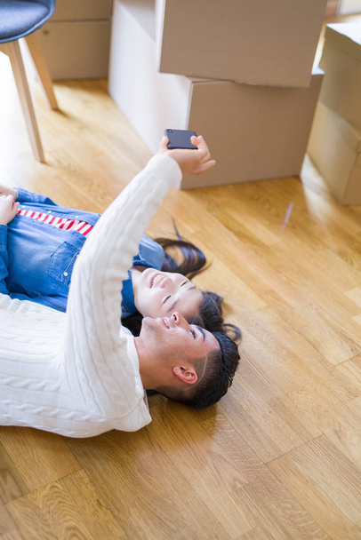 Young asian couple lying on the floor of new house smiling happy - Photo, Image