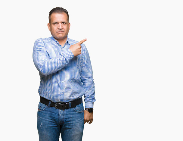Арабський бізнесмен середнього віку над ізольованим тлом Вказуючи пальцем на бік показуючи рекламу, серйозне і спокійне обличчя
 - Фото, зображення