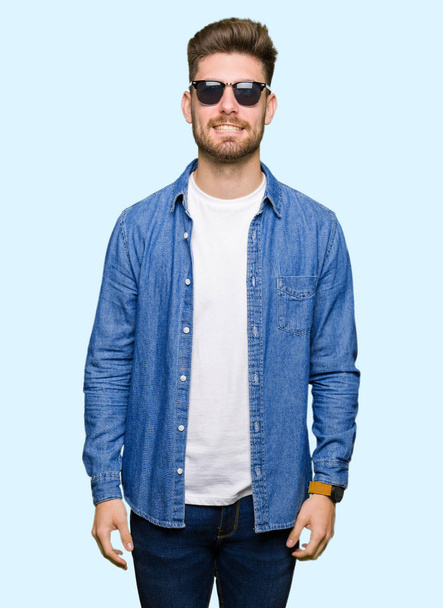 Mladý pohledný elegantní muž nosí džínová bunda s príma úsměvem na tváři. Šťastný člověk. - Fotografie, Obrázek
