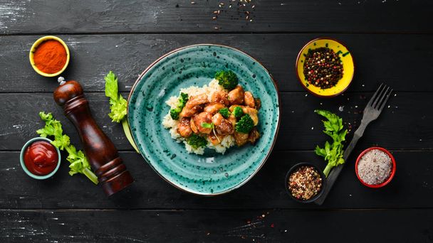 Rice with chicken fillet and broccoli. Thai cuisine. In the plate. Top view. Free space for your text. Rustic style. - Photo, Image