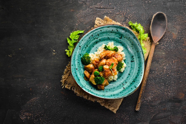 Rice with chicken fillet and broccoli. Thai cuisine. In the plate. Top view. Free space for your text. Rustic style. - Foto, imagen