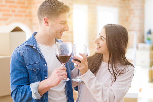 Young beautiful couple drinking a glass of wine celebrating movi - 写真・画像