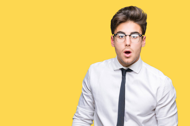 Young business man wearing glasses over isolated background afraid and shocked with surprise expression, fear and excited face. - Photo, Image