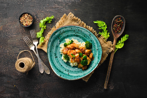 Rice with chicken fillet and broccoli. Thai cuisine. In the plate. Top view. Free space for your text. Rustic style. - Foto, Bild