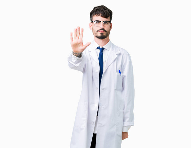 Young professional scientist man wearing white coat over isolated background doing stop sing with palm of the hand. Warning expression with negative and serious gesture on the face. - Photo, Image