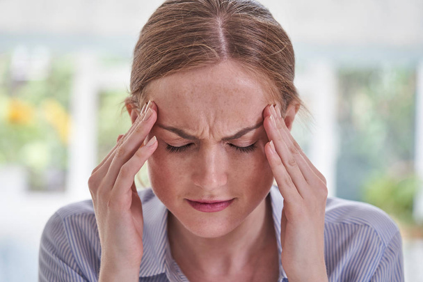 Nahaufnahme einer jungen Frau mit Kopfschmerzen - Foto, Bild