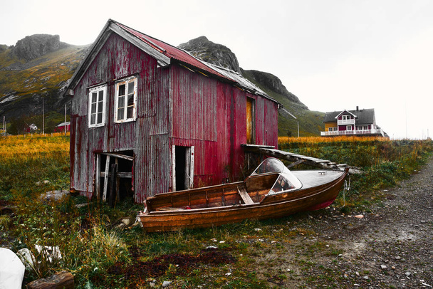 Old damaged and weathered wooden boat house at the coast of Vinstad on Lofoten Islands in Norway - Foto, immagini