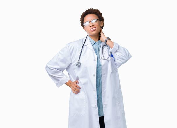 Mladý africký americký lékař žena nosí lékařský kabát přes izolované pozadí utrpení poranění krku, bolest, dotýkat krku, rukou, bolest svalů - Fotografie, Obrázek