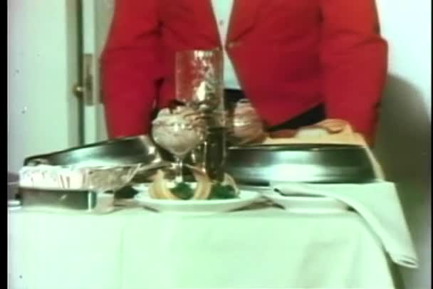 Low section of waiter wheeling meal on food trolley - Кадри, відео
