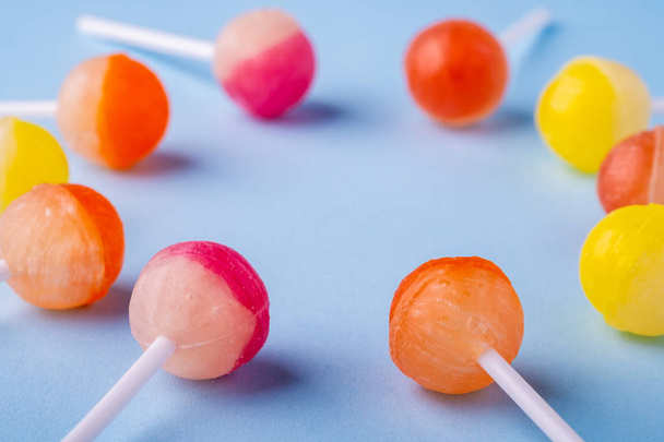 Cirkel van Lollipop snoepjes op blauwe achtergrond hoek aanzicht - Foto, afbeelding