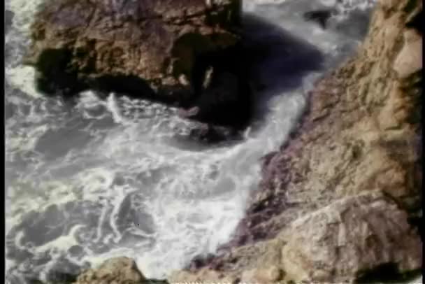 岩の崖にはねかける波の高角度のビュー - 映像、動画