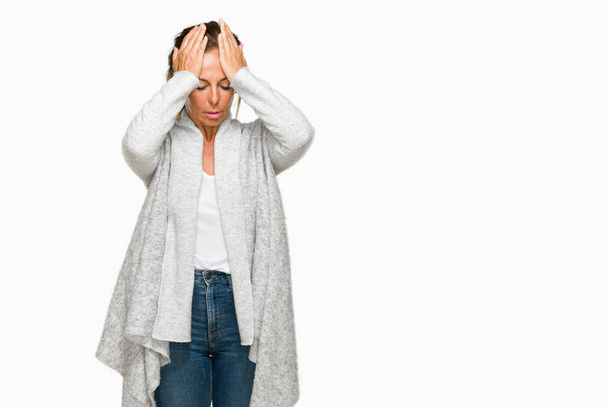 Beautiful middle age adult woman wearing winter sweater over isolated background suffering from headache desperate and stressed because pain and migraine. Hands on head. - Foto, Imagen