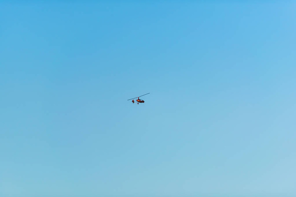 Вертоліт летить проти синього неба. Повітряний транспорт на небі. Відпочинок в Киргизії. Поїздка в Іссик-куль озеро. - Фото, зображення