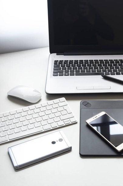 Ensemble technologique Ordinateur portable blanc, tablette graphique, téléphone intelligent, souris et clavier, sur fond blanc
. - Photo, image
