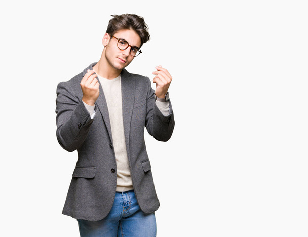 Giovane uomo d'affari che indossa occhiali su sfondo isolato facendo gesti di denaro con mano, chiedendo il pagamento dello stipendio, affari milionario
 - Foto, immagini
