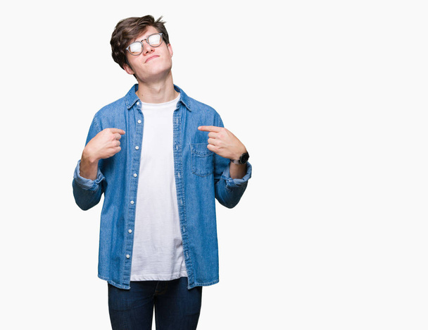 Mladý pohledný muž nosí brýle izolované pozadí sebevědomým úsměvem na tváři, polohovací sebe prsty hrdý a šťastný. - Fotografie, Obrázek