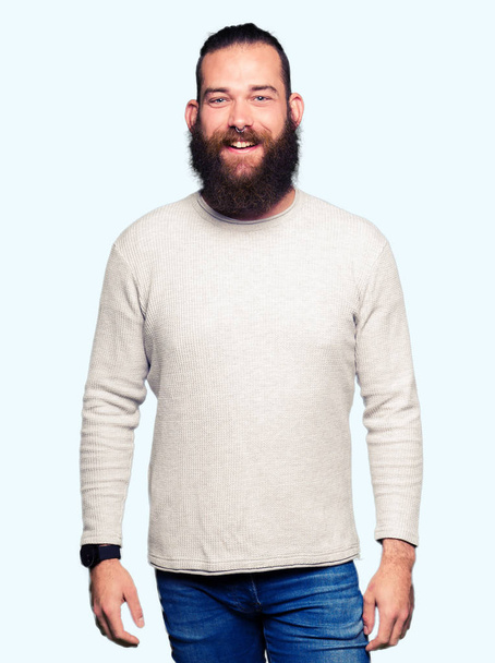 Fiatal szőke ember visel alkalmi pulóver, egy boldog és hűvös mosollyal az arcán. Szerencsés személy. - Fotó, kép