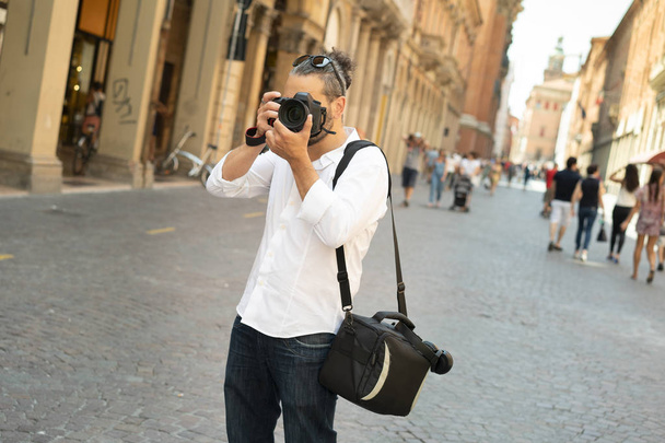 Fotografo in camicia bianca scattae nel centro cittadino in una giornata di sole estivo - Foto, immagini