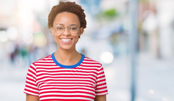 Красива молода афро-американських жінка в окулярах над ізольованих фону з щасливим і прохолодний усмішкою на обличчі. Щаслива людина. - Фото, зображення