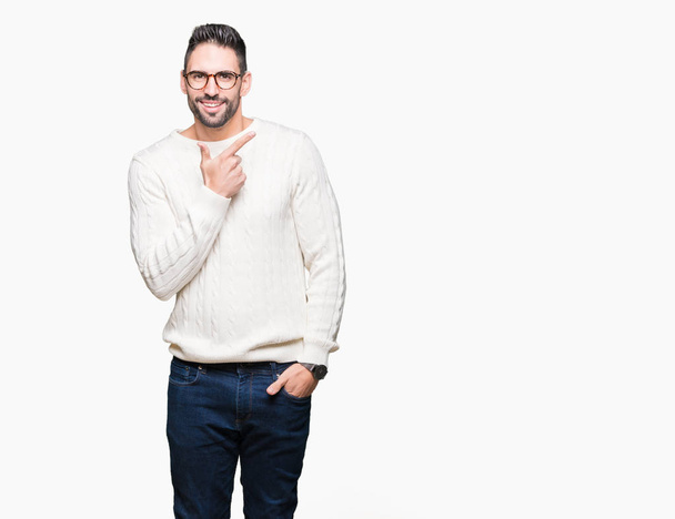 Young handsome man wearing glasses over isolated background cheerful with a smile of face pointing with hand and finger up to the side with happy and natural expression on face - Photo, Image