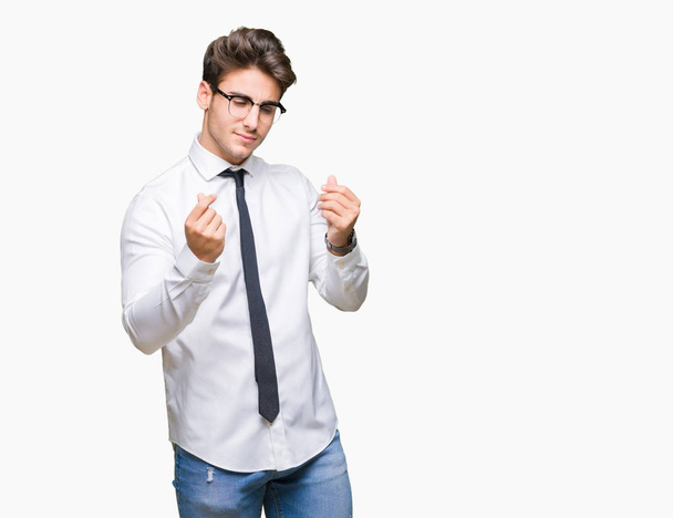 Mladí obchodní muž nosí brýle nad, samostatný pozadí dělá peníze gesto rukou, žádá o vyplacení mzdy, milionář podnikání - Fotografie, Obrázek