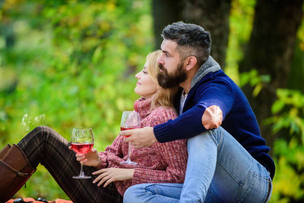 Family picnic. Happy couple. happy woman and bearded man drink wine. love date and romance. Spring mood. Red wine in fall weather. couple in love relax in autumn forest. I know everything about wine - Photo, Image