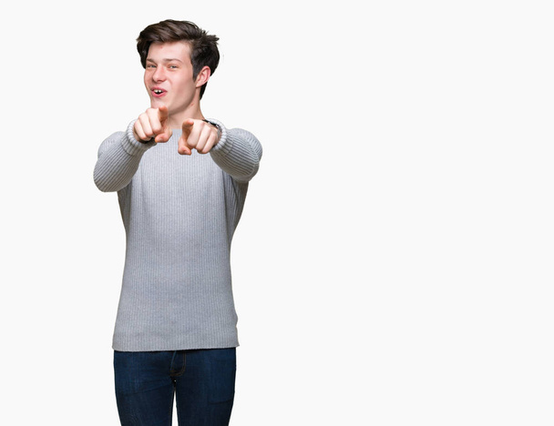 Jonge knappe man dragen winter trui over geïsoleerd background Pointing aan u en de camera met de vingers, positief en vrolijk lachend - Foto, afbeelding