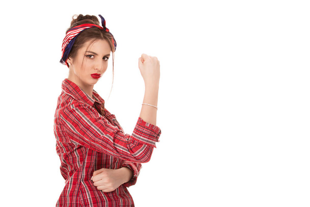confident woman with a clenched fist rolling up her sleeve - Photo, image