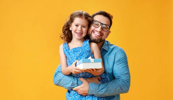 . happy father's day! cute dad and daughter hugging on yellow ba - 写真・画像