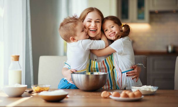 happy family in kitchen. mother and children preparing dough, ba - Photo, Image