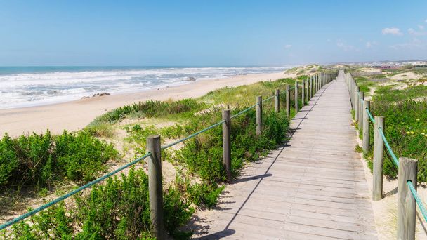 Praia da Frente Azul 'da tahta tahta kaldırım, İngilizcede deniz kıyısındaki tatil beldesi Espinho' nun mavi plaj cephesi. - Fotoğraf, Görsel