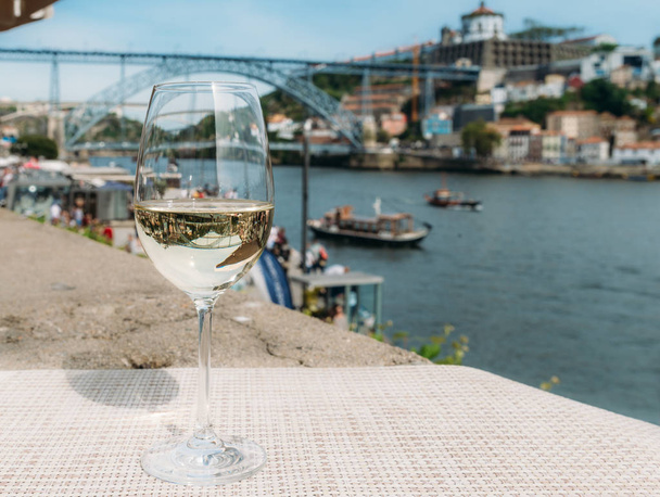 Copo de vinho branco com vista para o Cais da Ribeira, no Rio Douro, no Porto, Portugal
 - Foto, Imagem