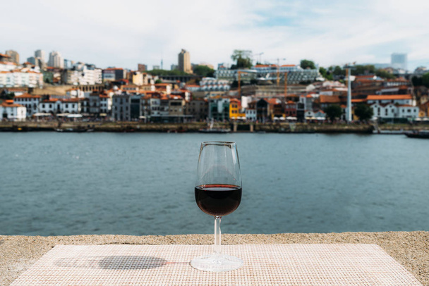 Glas rode Port wijn met uitzicht op Vila Nova de Gaia, Porto, Portugal - Foto, afbeelding