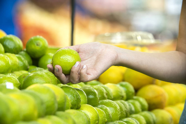 Woman's hand choosing lemons in supermarket  - Fotó, kép