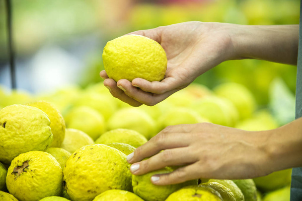 Woman's hand choosing guavas in supermarket  - Фото, изображение