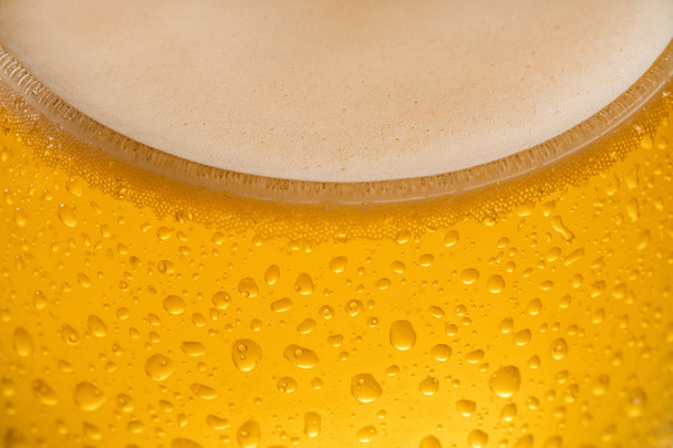 滴と泡で冷たいビールのクローズアップ - 写真・画像