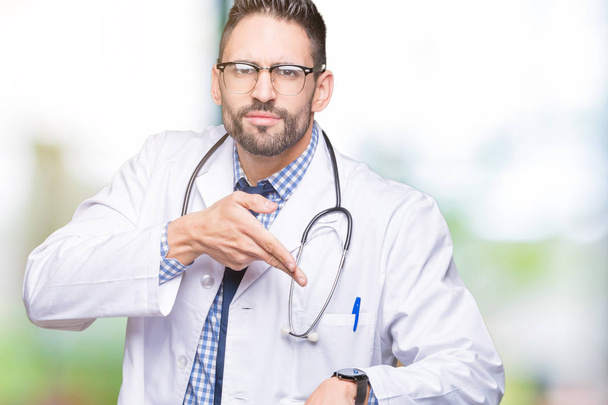 Handsome young doctor man over isolated background In hurry pointing to watch time, impatience, upset and angry for deadline delay - Photo, Image