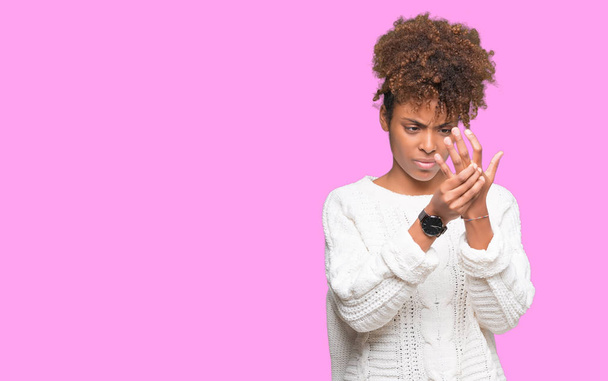 孤立した背景の手と指、関節炎の炎症の痛みに苦しんで上冬セーターを着ている美しい若いアフリカ系アメリカ人女性 - 写真・画像