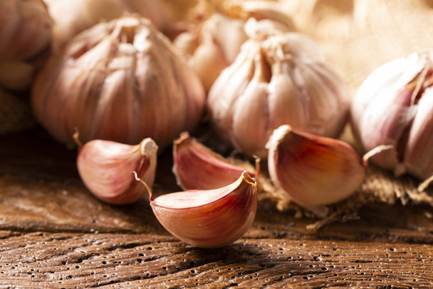 Garlic close up, Garlic bulb, Garlic cloves in jute sack on wooden background - Foto, Imagem