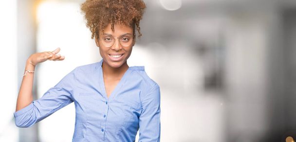 Beautiful young african american business woman over isolated background gesturing with hands showing big and large size sign, measure symbol. Smiling looking at the camera. Measuring concept. - Fotografie, Obrázek