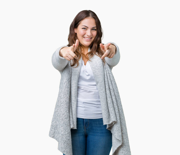 Młoda kobieta piękne plus size noszenia kurtka zimowa na na białym tle tła Pointing do Ciebie i aparat palcami, uśmiechając się pozytywny i wesoły - Zdjęcie, obraz