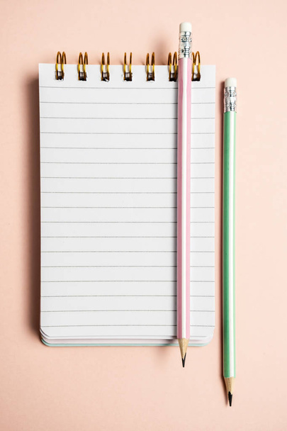 Vista superior del cuaderno en blanco con divertida pluma esponjosa en pastel rosa
  - Foto, imagen