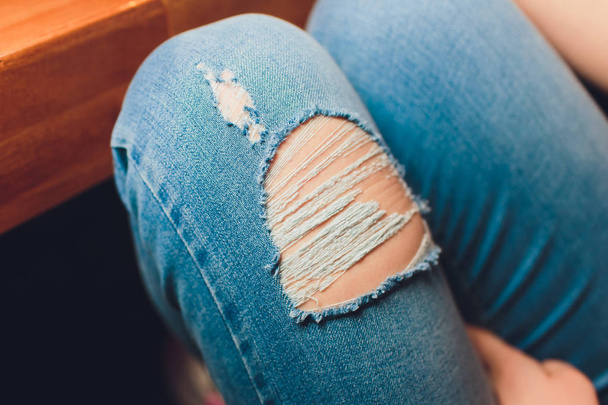 Woman in torn jeans blue texture fashion. - 写真・画像